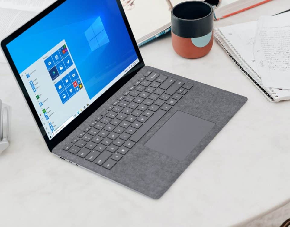 gray microsoft surface laptop computer on white table